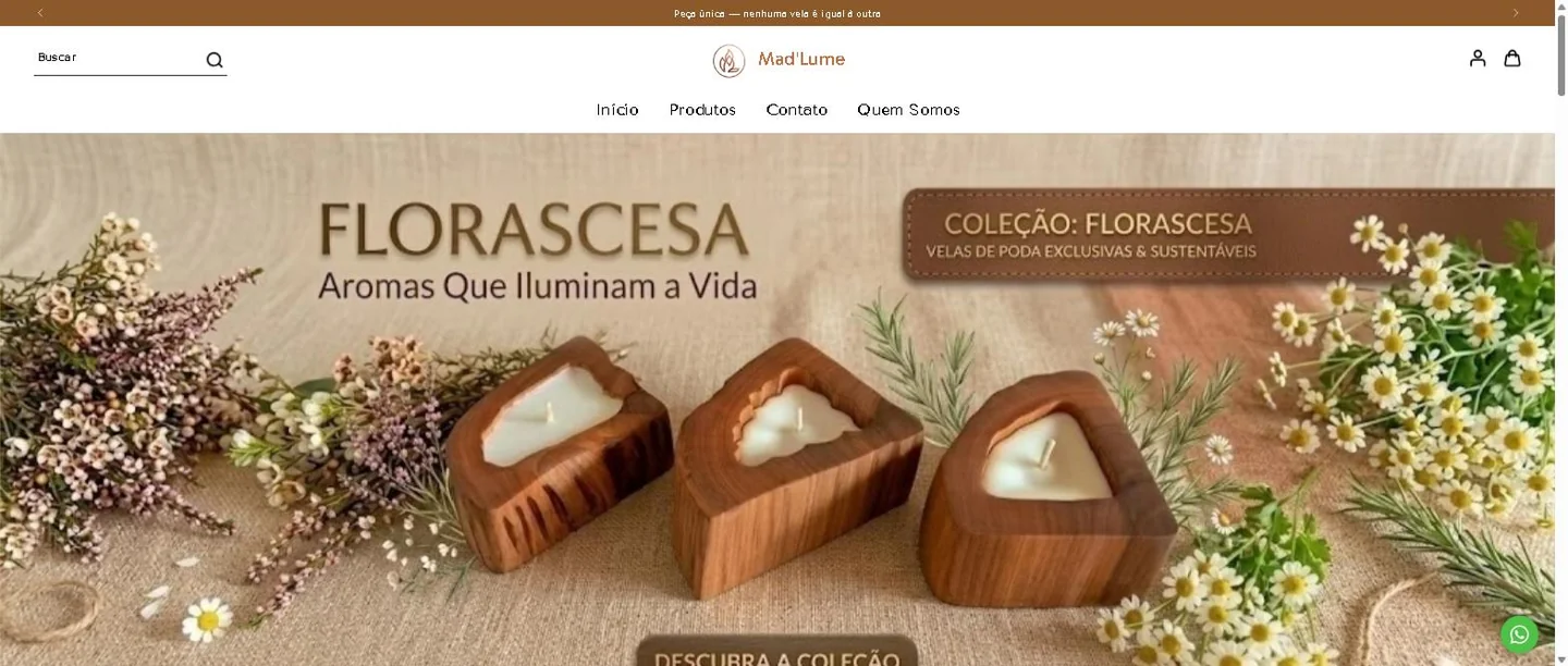 Página inicial da loja Mad'Lume com o banner da coleção Florascesa e três velas em tronco de madeira